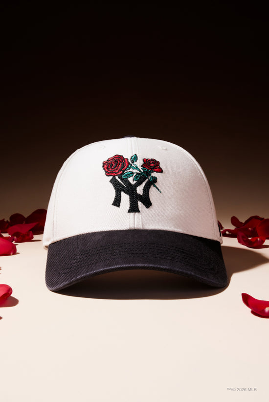 Slide 1:Black and White cap with roses motif on the front of a New York Yankees logo